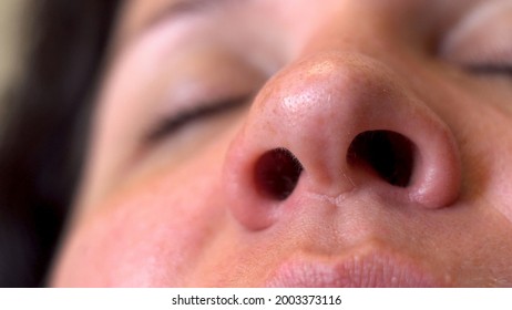 Nasal breathing. Woman's face. Movement of the nostrils. Inhalation of air. Part of the face. Big nose. A sick man. Oxygen breathing. Macro. Close-up.