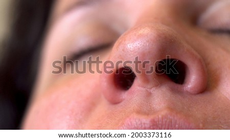 Nasal breathing. Woman's face. Movement of the nostrils. Inhalation of air. Part of the face. Big nose. A sick man. Oxygen breathing. Macro. Close-up.