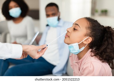 Nasal Coronavirus PCR Test. Doctor using cotton swab stick to take covid virus specimen from potentially infected black teen girl at home. Viral disease prevention and diagnostics concept - Shutterstock ID 2051522213