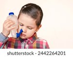 Nasal Irrigation for Nose or Sinus Rinse, Nasal Rinse for Children. Little Girl Child Washing her Nose with Saline Solution with Rinse Bottle. Nose Shower. Copy Space. 