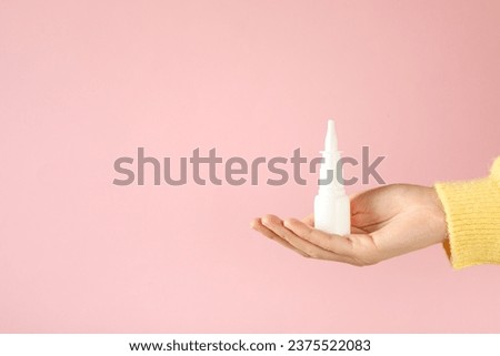 Nasal spray in hand. Concept of winter medicine
