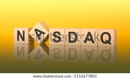 NASDAQ word written on wood block. inscription on the cubes is reflected from the surface of the table. color gradient is used. NASDAQ - National Association of Securities Dealers Automated Quotation