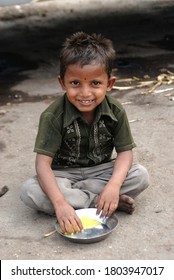 Nashik; Maharashtra; India; Feb. 03; 2008 - Indian Village Boy Pilgrim Eating Food On Open Land Near Banks Of Holy Godavari River Nashik