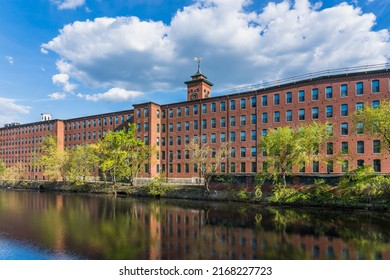 Nashua, New Hampshire, USA. 05-16-2021. Historical Building Of A Cotton Factory With A Clock Tower In An Old Industrial Park  On Nashua River 