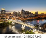 Nashville, Tennessee, USA skyline over the Cumberland River at golden hour.