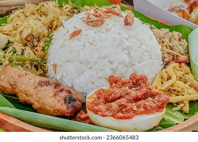 nasi bali is most favorite food in bali, with chicken satay, , boiled egg and some of vegetables serving with sambal or chili sauce  - Shutterstock ID 2366065483