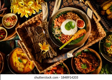 Nasi Campur Bali. Balinese meal of steamed rice with chicken, vegetable, egg, noodle, peanuts and satay; set among other side dishes as optional extra. - Shutterstock ID 1848914203