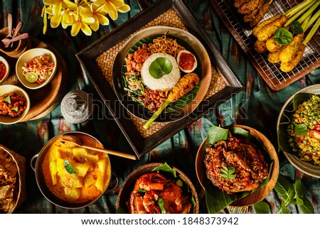 Nasi Campur Bali. Balinese meal of steamed rice with chicken, vegetable, egg, noodle, peanuts and satay; set among other side dishes as optional extra.