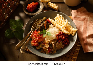 Nasi Campur. Indonesian Meal Of Rice With Side Dishes Of Beef Stew In Green Chili Paste, Shrimp In Red Chili Paste, Stirfried Banana Blossom, Peanut Anchovy And Tapioca Crackers.