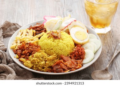 Nasi kuning or sometimes called nasi kunyit is an Indonesian dish of fragrant rice cooked with coconut milk and turmeric, hence the name nasi kuning - Shutterstock ID 2394921313