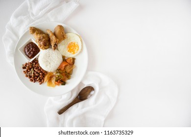 Nasi Lemak Flatlay On White Table. Singapore Food, Malaysian Food Called Nasi Lemak Or Coconut Rice, Shot Top Down. Nasi Lemak With Copy Space. 