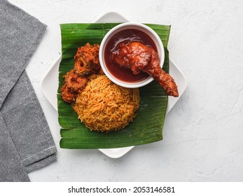 Nasi Lemak With Fried Squid And Rendang Chicken On Banana Leaf In White Background Top View