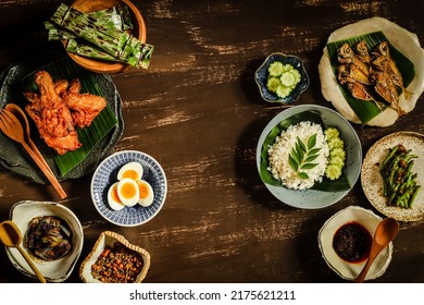 Nasi Lemak. Malay Meal Of Savory Steamed Rice With Variety Of Side Dishes Of Fried Chicken, Fried Fish, Egg, Vegetable Stir-fry, Peanut Anchovy Crisps, Fish Cake In Banana Leaf And Chili Paste.