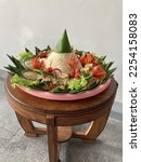 Nasi tumpeng on banana leaf for celebration on wooden table. Indonesian cuisine