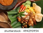 Nasi Uduk Betawi. Coconut flavored steamed rice dish from Betawi, Jakarta. Served with fried chicken, sauteed tempeh, omelet, cracker crisps, fresh vegetables and spicy peanut sauce.