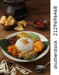 Nasi uduk is a typical Indonesian food made from rice cooked with coconut milk, served with eggs, tempeh and potatoes,selective focus