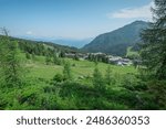 Nassfeld ski slope in summer. Visible lower ski lift station  overlooking green meadows under the blue sky. Alpine panorama in summer