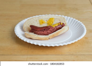 Nasty looking hotdog on a paper plate.