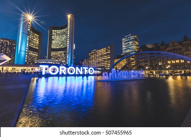 Nathan Phillips Square In Toronto At Night, With The Fountain, The Big Writing And The Old City Hall In The Right. Long Exposure Shot.