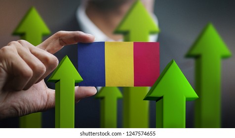 Nation Growth Concept, Green Up Arrows - Businessman Holding Card Romania Flag  - Powered by Shutterstock