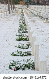 The National Cemetery In Santa Fe, New Mexico Is Covered In Snow.  The Monuments Have Been Decorated With Christmas Wreaths.