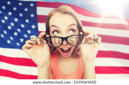 national, education and people concept - happy surprised young woman or teenage girl eyeglasses over american flag background