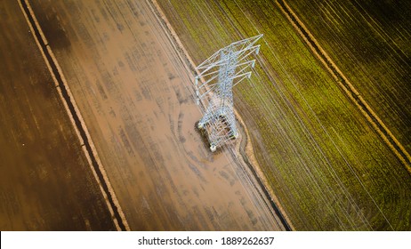 National Electricity Grid From Top View With Abstract. Aerial View Of Power Line Pylon In Open Paddy Field.