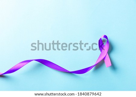 National Epilepsy or Alzheimer disease Day Concept. Purple ribbon symbol of Pancreatic cancer awareness and world Lupus Day and world cancer isolated blue background
