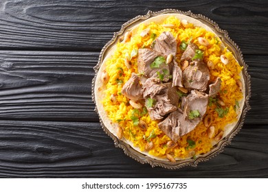 National favorite in Jordan mansaf is an offshoot of traditional Bedouin cuisine that makes for a delightful communal meal closeup in the plate on the table. Horizontal top view from above - Shutterstock ID 1995167735