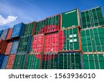 The national flag of Bangladesh on a large number of metal containers for storing goods stacked in rows on top of each other. Conception of storage of goods by importers, exporters