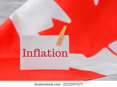 The National Flag of Canada. Canadian Flag with the Maple Leaf and paper note message text INFLATION. global hunger, high prices, increasing living expenses and poverty, financial crisis, food supply - Shutterstock ID 2212597577
