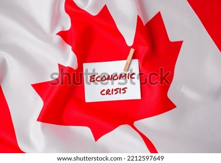 The National Flag of Canada. Canadian Flag with the Maple Leaf and paper note message text ECONOMIC CRISIS. global hunger, inflation, high prices, increasing living expenses and poverty, financial