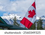 National Flag of Canada with Snowcapped Roche Bonhomme mountain. Jasper National Park, Alberta, Canada.