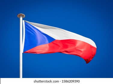 The national flag of the Czech Republic. Based on the flag of Bohemia. Czechoslovakian flag blowing in strong wind against a pure blue sky. Symbol of national patriotism.
