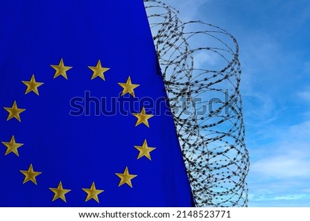 national flag of European Union on concrete wall, barbed wire fence, concept of prison, symbol of police state, territory border, totalitarian regime, restriction of rights and freedoms of citizens