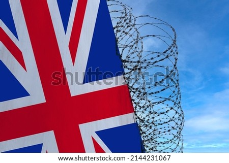 national flag of Great Britain on concrete wall, barbed wire fence, concept of prison, symbol of police state, territory border, totalitarian regime, restriction of rights and freedoms of citizens