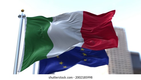 The National Flag Of Italy Waving In The Wind Together With The European Union Flag Blurred In The Background. Politics And Finance. Italy Is A Member State Of The European Union