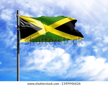 National flag of Jamaica on a flagpole in front of blue sky.