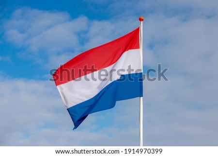 National flag of the Netherlands with horizontal tricolour of red, white and blue, Dutch flag waving on the air in a sunny day as background.