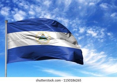 National flag of Nicaragua on a flagpole in front of blue sky