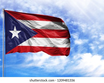 National flag of Puerto Rico on a flagpole in front of blue sky