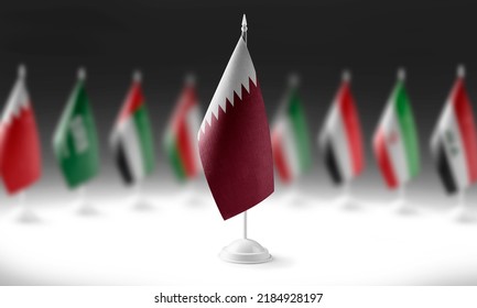 The national flag of the Qatar on the background of flags of other countries