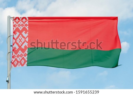 the national flag of the Republic of Belarus on a blue sky background, the flag of Belarus on a blue background