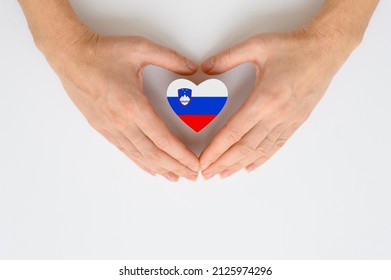 The national flag of Slovenia in female hands. The concept of patriotism, respect and solidarity with the citizens of Slovenia. - Shutterstock ID 2125974296