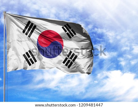 National flag of South Korea on a flagpole in front of blue sky