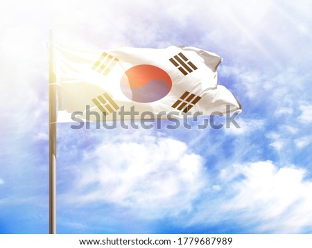 National flag of South Korea on a flagpole in front of blue sky