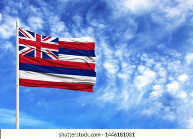 National flag State of Hawaii on a flagpole in front of blue sky