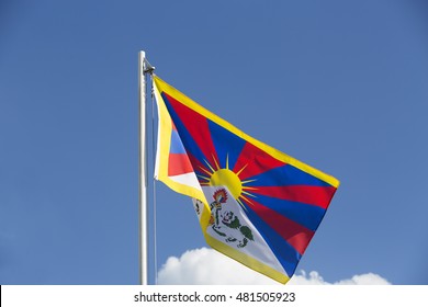 National flag of Tibet on a flagpole in front of blue sky