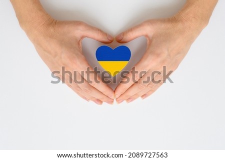 The national flag of Ukraine in female hands. The concept of patriotism, respect and solidarity with the citizens of Ukraine.