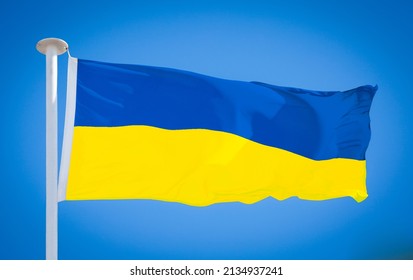 The national flag of Ukraine, from the Kingdom of Galicia–Volhynia in the 12th century. This blue-yellow bicolour has been used since 1848. Flag blowing in strong wind against a pure blue sky.